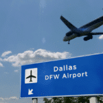 A plane is flying over the entrance to Dallas DWW Airport.