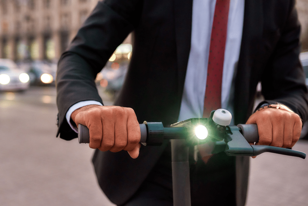A micro-man in a suit riding a bicycle with a light on it.