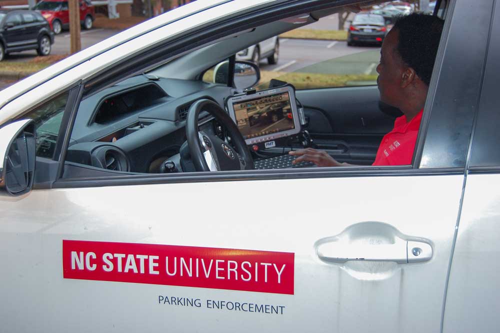 NC State Parking Enforcement Officer Jerome sitting in vehicle looking at LPR License Plate Recognition on computer