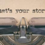 An old typewriter with the words what's your story? inviting storytelling.