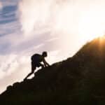 person climbing up hill inspirationally