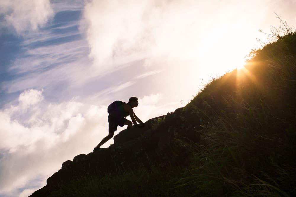 person climbing up hill inspirationally