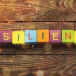 The word resilience spelled out in colorful blocks on a wooden background, showcasing the application of technology.