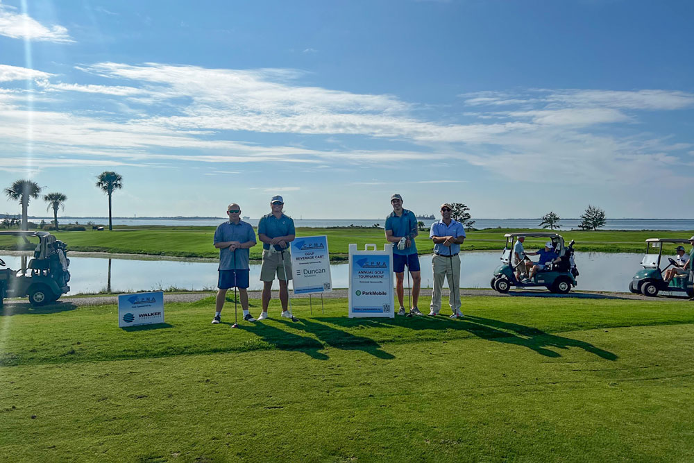 A group of people posing for a photo on a golf course, captured during an annual CPMA event.