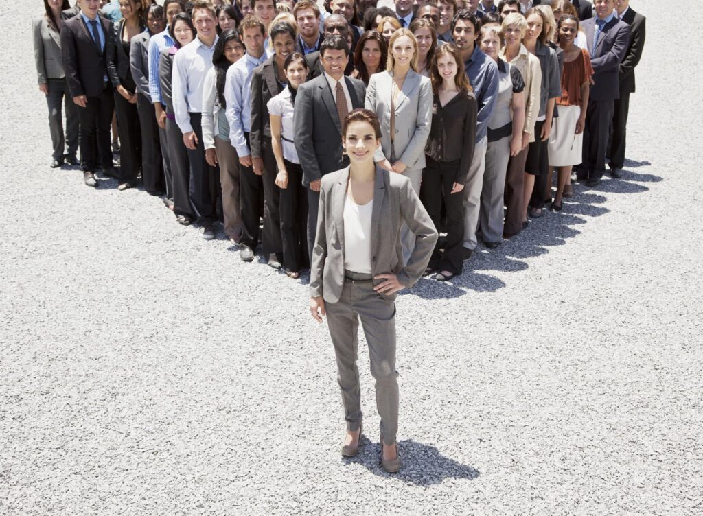 A group of business people standing in a heart shape, demonstrating their management skills and commitment to fulfilling demands and achieving rewards.
