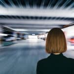 Photo of a woman from behind looking at a blurred image of a parking garage