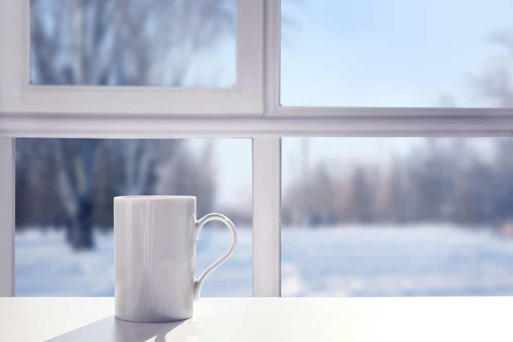 white coffee much in a brightly lit window with snow outside