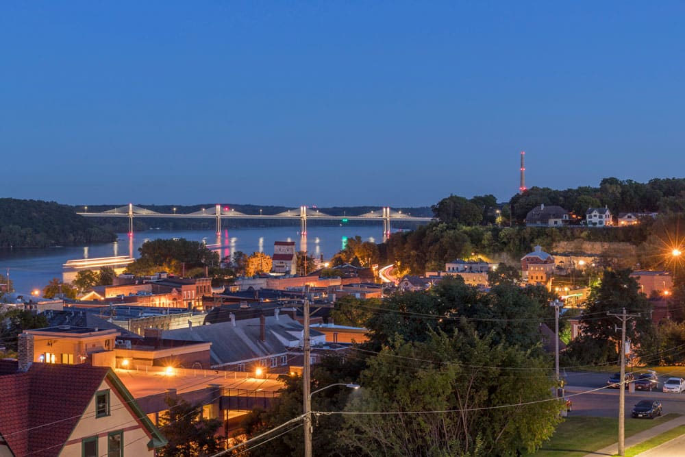 A view of a Smart City at dusk with a bridge in the background, showcased as an IoT Breakthrough Awards winner with the eXactpark technology.