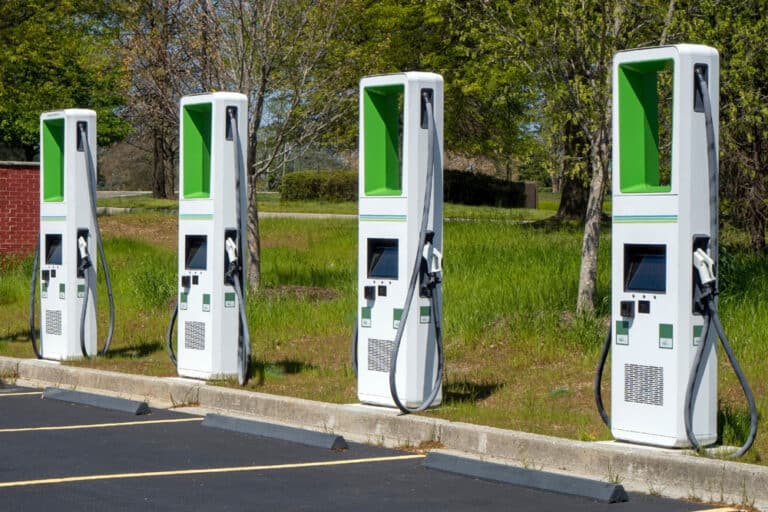 A row of electric car charging stations in a parking lot, showcasing the innovative use of IoT technology for a Smart City.