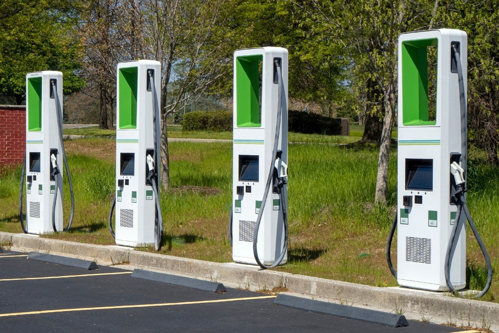 A row of electric car charging stations in a parking lot, showcasing the innovative use of IoT technology for a Smart City.