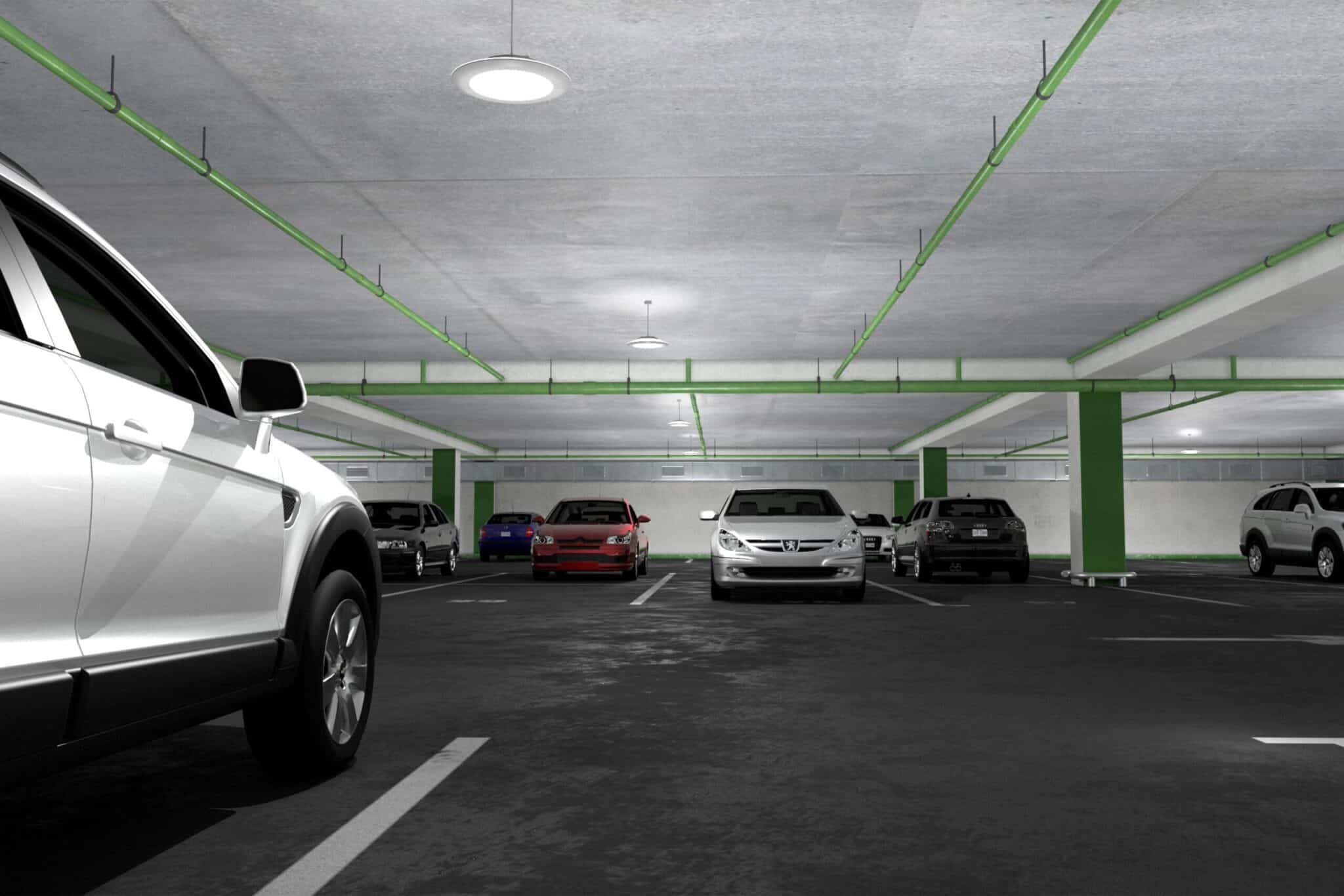 A white car is parked in a parking garage illuminated with upgraded lighting from Illuminating Ideas.
