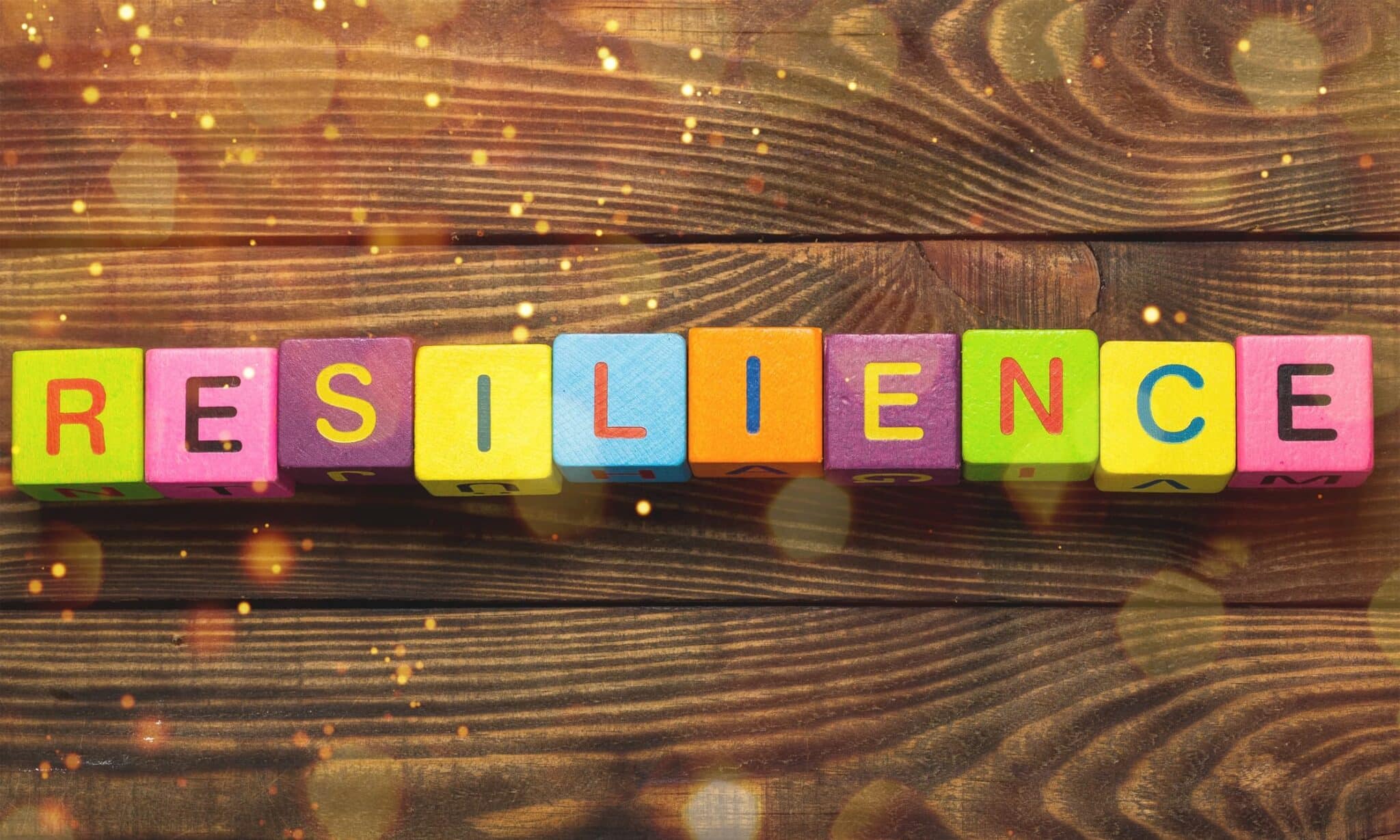 The word resilience creatively displayed in colorful blocks on a wooden background, inspiring ways to build resilience.