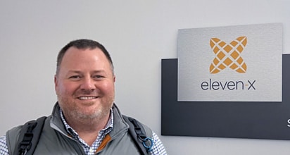 Jon Evens standing in front of eleven-x logo