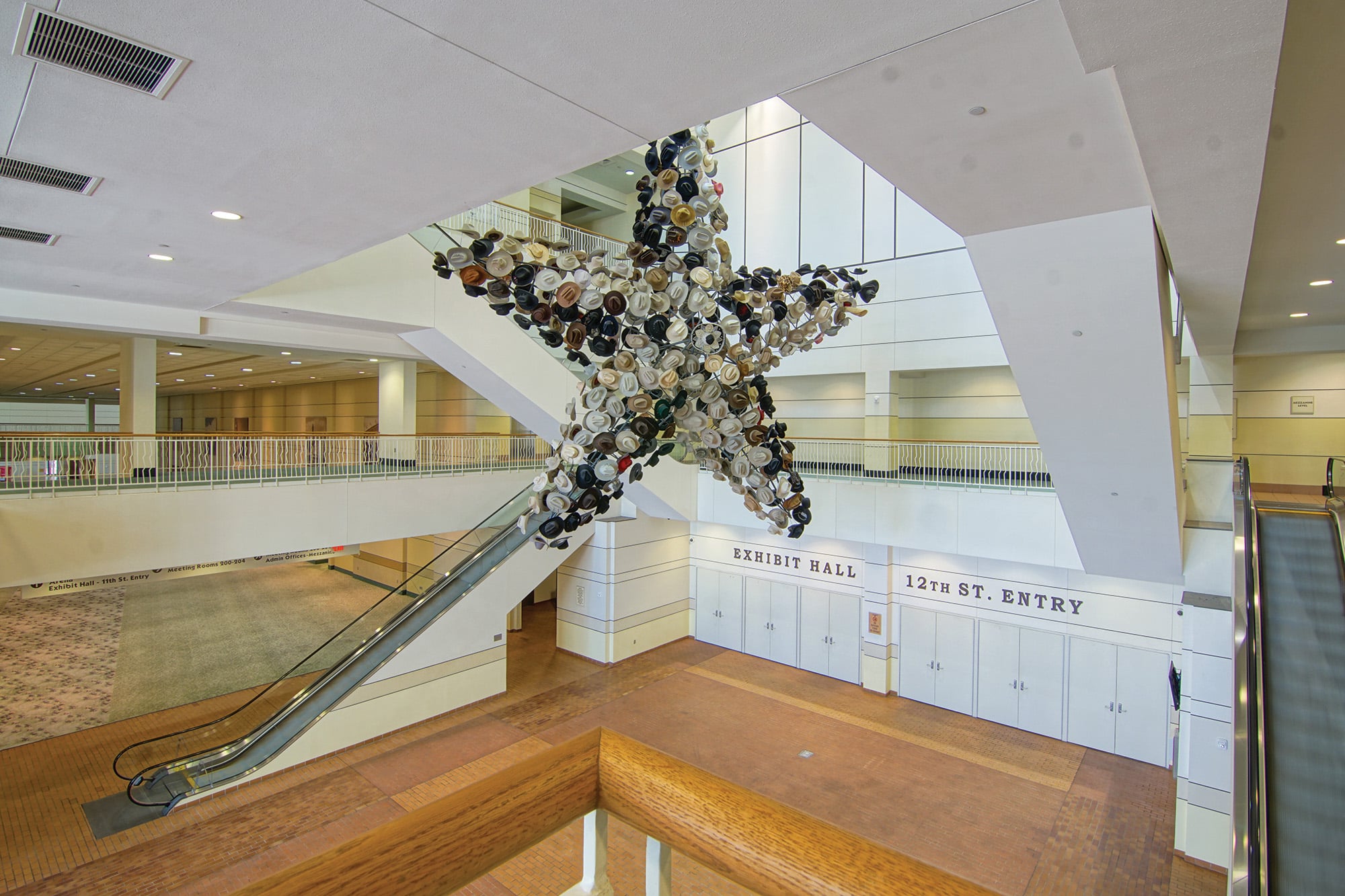 Wide shot of empty Fort Worth Convention Center featuring a large star made out of cowboy hats hanging in-between staircases.