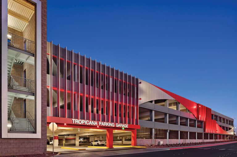 Photo of the UNLV Tropicana Parking Garage lit up with red lights at night