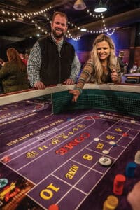 Man and woman rolling dice on a craps table