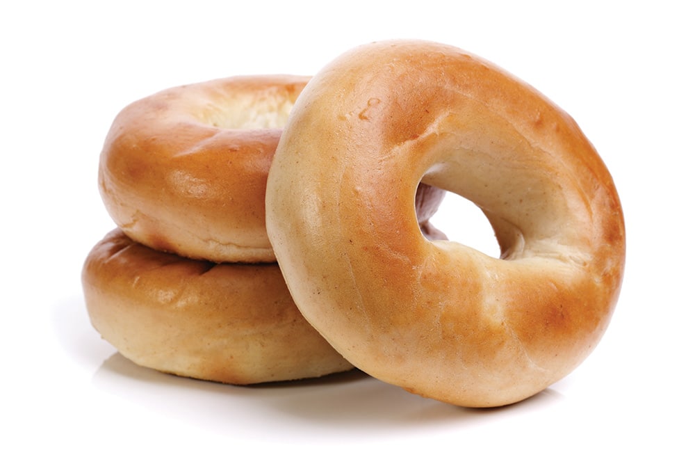 3 plain bagels that are isolated on a white background