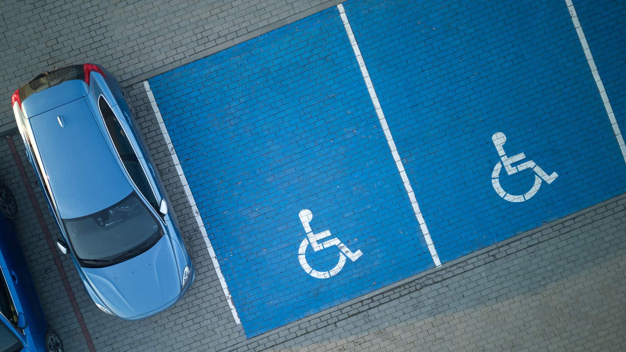 Overhead shot of a parked car and empty Accessible parking spaces