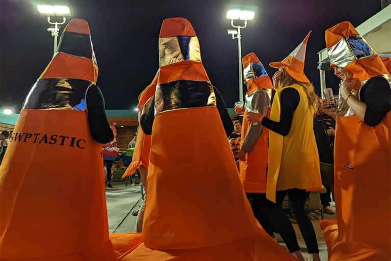 People dressed up as orange construction cones at night