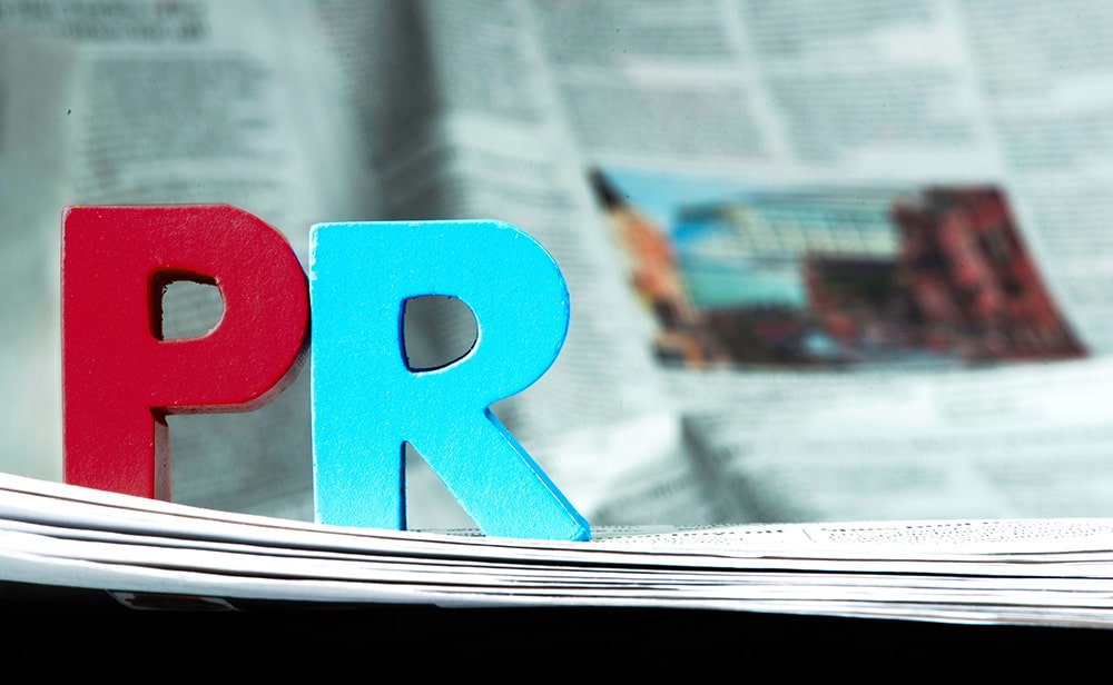 The letters "PR" on top of an out of focus newspaper