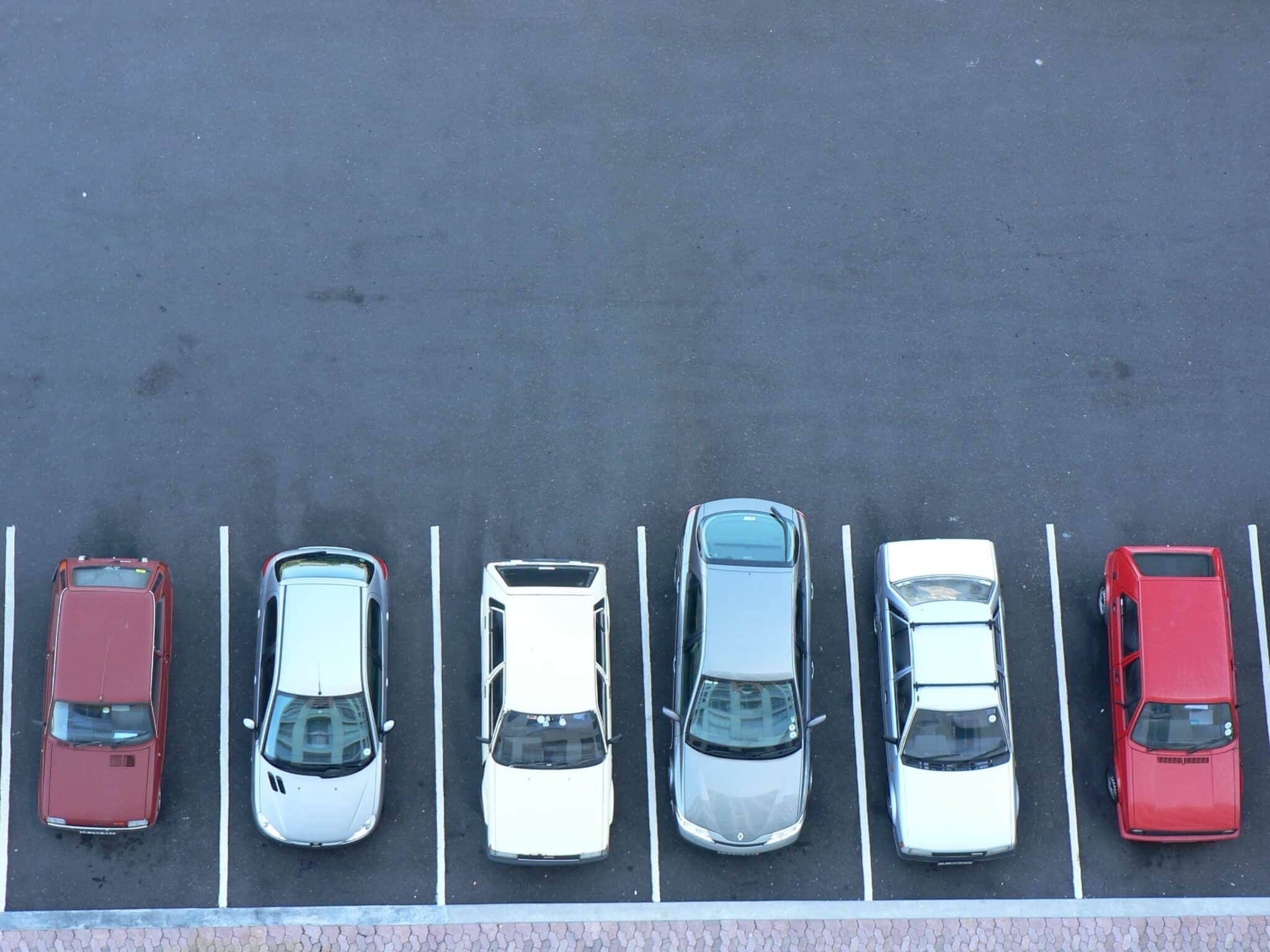 Overhead shot of cars parked in parking spaces