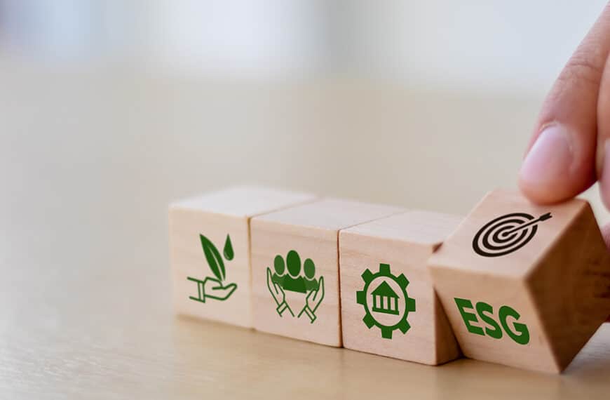 Hand flipping a wooden block in a series with ESG sustainability icons.