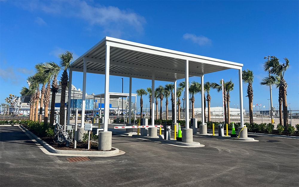 Covered parking area with palm trees and clear blue sky.