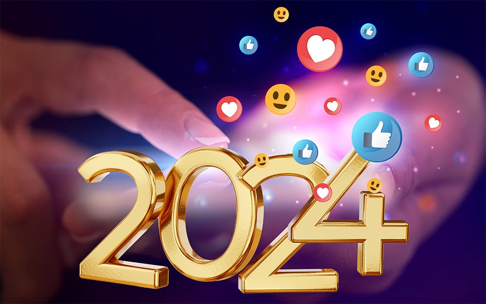 A hand holding a gold 2024 symbol with social media icons on it.