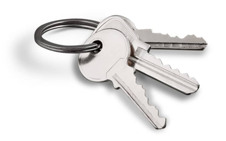 Three metal keys on a keyring isolated on a white background.