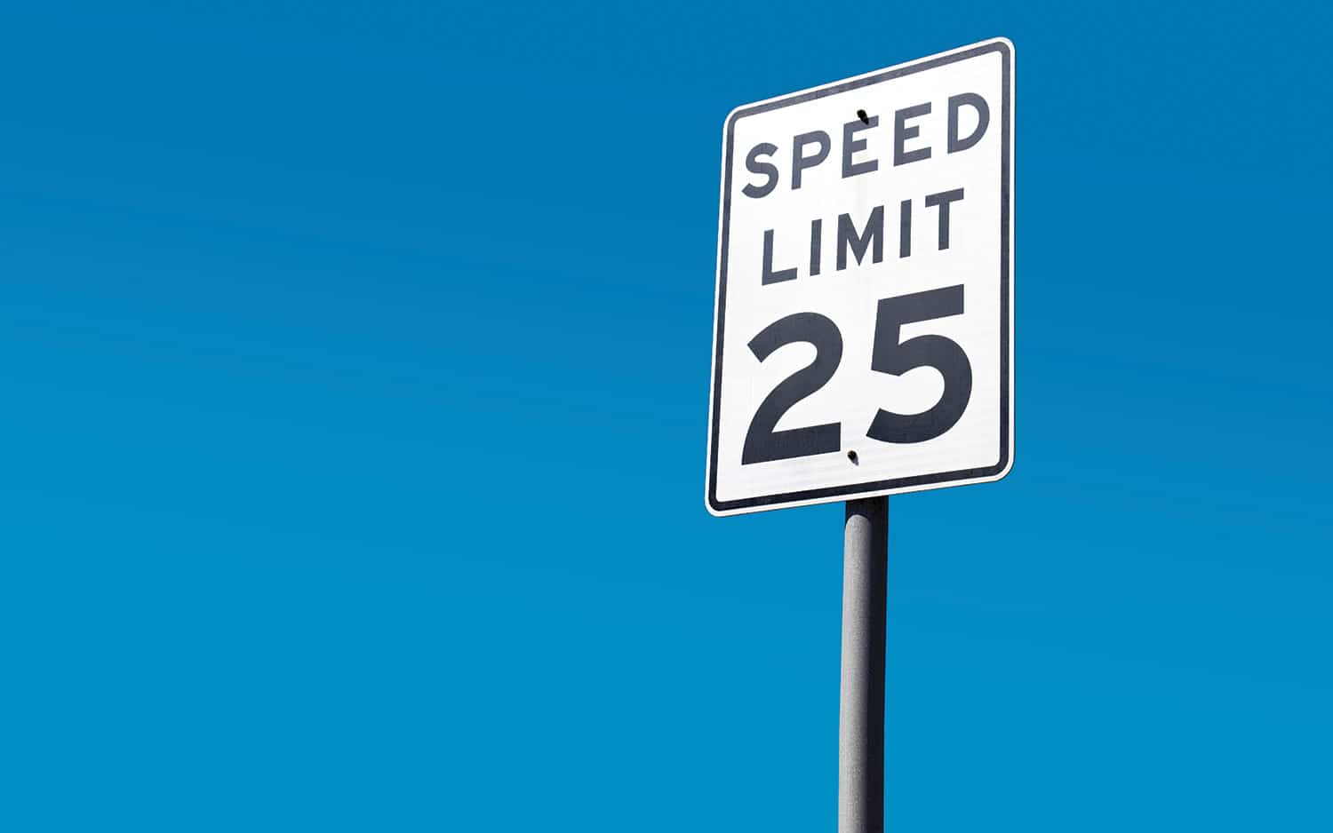 A "speed limit 25" sign against a clear blue sky.