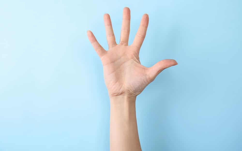 Open hand raised against a blue background.