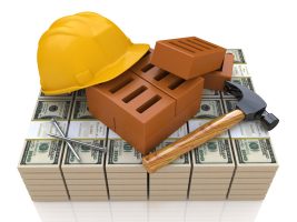 Construction materials on a stack of hundred dollar bills