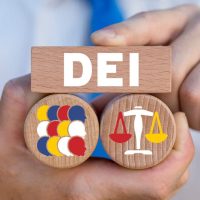 A man holding a wooden block with the word "dei" on it, showcasing his expertise in the Parking Industry.